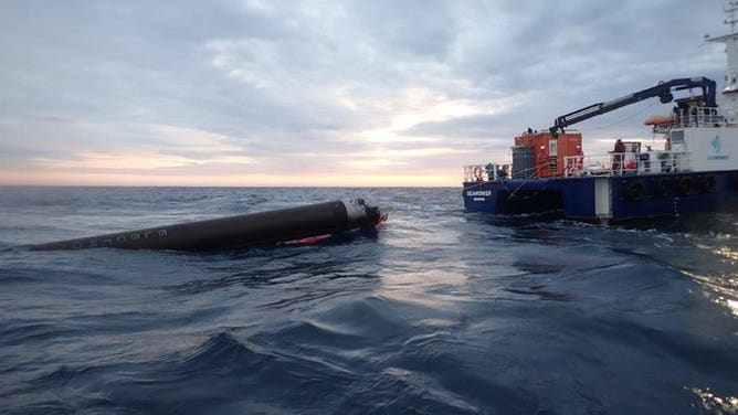 A Rocket Lab Electron rocket in the Pacific Ocean after landing and the marine recovery vessel.