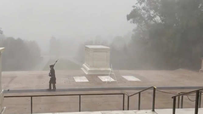 A Sentinel from The Old Guard marches in front of the Tomb of the Unknown Soldier on Saturday, July 29, 2023 during severe weather.