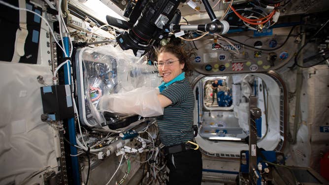 In this NASA file photo astronaut Christina Koch, Expedition 60 flight engineer, works with the BioFabrication Facility made by Techshot, now part of Redwire Corp.