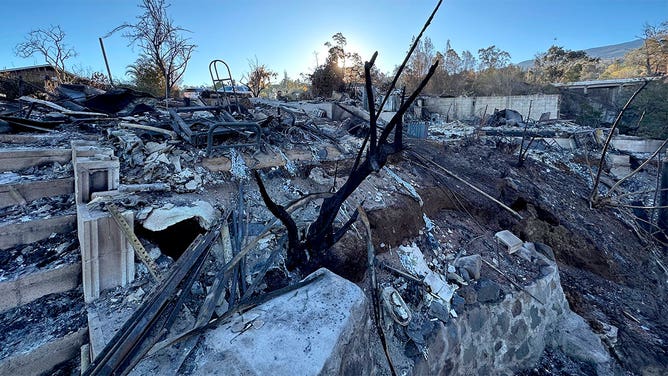 The sun rises over the ashes left behind by wildfires on the island of Maui in Hawaii on Aug. 15, 2023.