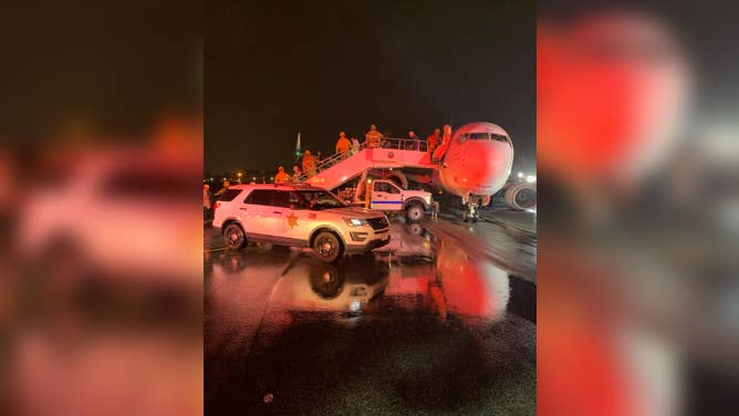 In the pouring rain, Orange County Fire Authority crews help passengers off Alaska Airlines flight 188 at John Wayne Airport in Santa Ana, California.