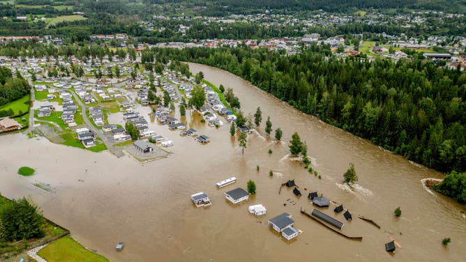 TOPSHOT - This aerial view taken on August 9, 2023 shows the camping site in Dokka flooded after the Dokka River overflowed its banks. Heavy rains caused flooding and landslides in Sweden and Norway on August 8 while strong winds caused a Danish wildfire to spread out of control, authorities said, with more heavy rain forecast. A storm dubbed "Hans" swept in over the Nordic countries over the weekend, leaving a path of destruction. Norway police reported several landslides in the southeast, with media reporting that over 100 people had been evacuated as a result.