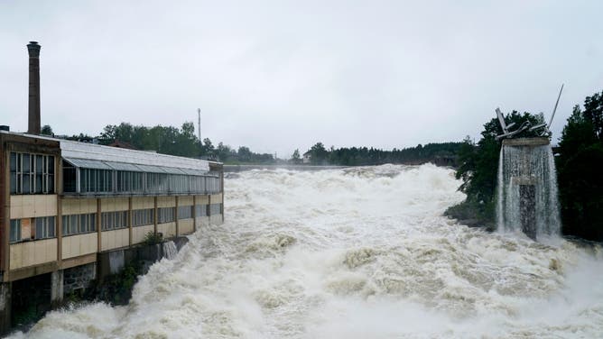 A photo shows the Storelva river flowing through Hoenefoss, Norway on August 9, 2023. Norwegian authorities said on August 9 thousands had been evacuated following massive floods and that they were considering blowing open a dam after the floodgates failed to open. Norway's armed forces said they had been asked to assist police at the Braskereidfoss hydroelectric power station, which lies along the Glomma river -- the longest in Norway -- to evaluate whether the gates would need to be blasted open.