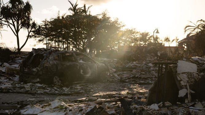 A burnt out car lies in the driveway of charred apartment complex in the aftermath of a wildfire in Lahaina, western Maui, Hawaii on August 12, 2023. Hawaii's Attorney General, Anne Lopez, said August 11, she was opening a probe into the handling of devastating wildfires that killed at least 80 people in the state this week, as criticism grows of the official response. The announcement and increased death toll came as residents of Lahaina were allowed back into the town for the first time.