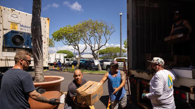 Volunteers unload donations at a distribution center for those affected by the Maui fires at Honokawai Beach Park in Napili-Honokowai, west of Maui, Hawaii, August 14, 2023. The death toll in Hawaii's wildfires rose to 99 and could double over the next 10 days, the state's governor said August 14, as emergency personnel painstakingly scoured the incinerated landscape for more human remains.