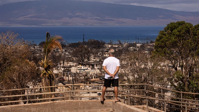 A man looks at burned buildings in the aftermath of the Maui wildfires in Lahaina, Hawaii on August 16, 2023.