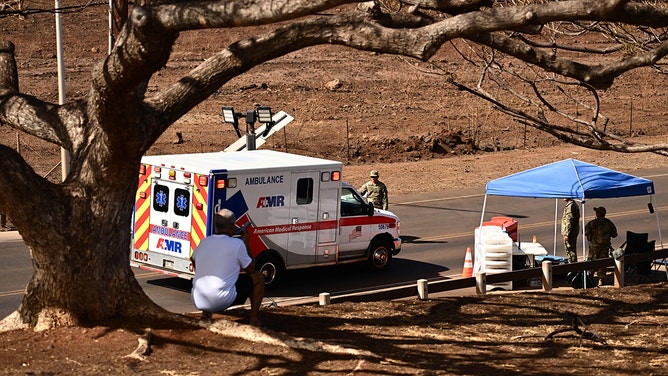An ambulance stops at a National Guard post in the aftermath of a wildfire in Lahaina, western Maui, Hawaii on August 16, 2023.