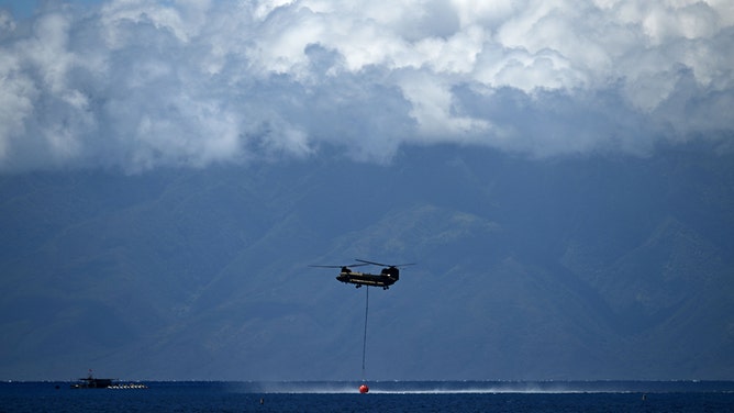A Hawaii Army National Guard Chinook helicopter gathers water from the ocean in the aftermath of the Maui wildfires in Lahaina, Hawaii on August 16, 2023.
