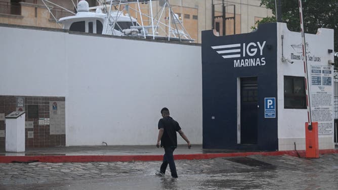 A man crosses a flooded street in Cabo San Lucas, Baja California State, Mexico, as rain and gusts of wind of Hurricane Hilary reach the area, on August 19, 2023. Mexico prepared Friday for a powerful Pacific hurricane that triggered a warning of "potentially catastrophic" flooding in a northwestern tourist region and the neighbouring US state of California. Hurricane Hilary threatened to bring strong winds, flash floods and "life-threatening" surf and rip current conditions, the US National Hurricane Center (NHC) said.