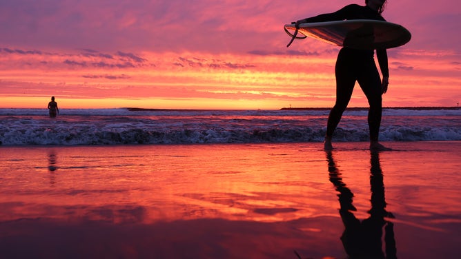 SAN DIEGO, CALIFORNIA - AUGUST 19: A surfer walks out of the Pacific Ocean at Ocean Beach shortly after sunset with Hurricane Hilary approaching on August 19, 2023 in San Diego, California. Southern California is under a first-ever tropical storm warning as Hurricane Hilary approaches with parts of California, Arizona and Nevada preparing for flooding and heavy rains.