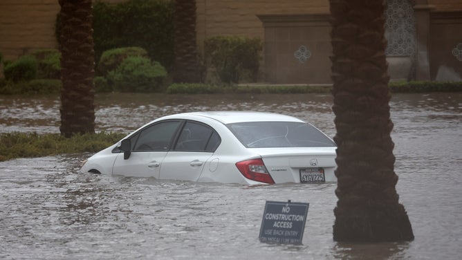 CATHEDRAL CITY, CALIFORNIA - AUGUST 20: A car is partially submerged in floodwaters as Tropical Storm Hilary moves through the area on August 20, 2023 in Cathedral City, California. Southern California is under a first-ever tropical storm warning as Hilary impacts parts of California, Arizona and Nevada. All California state beaches have been closed in San Diego and Orange counties in preparation for the impacts from the storm, which was downgraded from hurricane status.