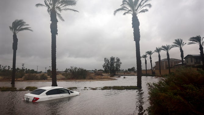 CATHEDRAL CITY, CALIFORNIA - AUGUST 20: A car is partially submerged in floodwaters as Tropical Storm Hilary moves through the area on August 20, 2023 in Cathedral City, California. Southern California is under a first-ever tropical storm warning as Hilary impacts parts of California, Arizona and Nevada. All California state beaches have been closed in San Diego and Orange counties in preparation for the impacts from the storm which was downgraded from hurricane status.
