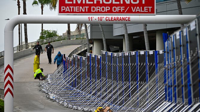 Workers set up a fence to prevent flooding at Tampa General Hospital in Tampa, Florida, on August 29, 2023 as the city prepares for Hurricane Idalia. Hurricane Idalia intensified Tuesday as it churned toward the west coast of Florida, triggering mass evacuation orders and flood alerts as authorities warned of life-threatening ocean surge and catastrophic destruction when the storm rages ashore early Wednesday. (Photo by Miguel J. Rodriguez Carrillo / Miguel J. Rodriguez Carrillo / AFP) (Photo by MIGUEL J. RODRIGUEZ CARRILLO/Miguel J. Rodriguez Carrillo/AFP via Getty Images)