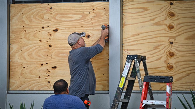 People board up a window in Tampa, Florida, on August 29, 2023 as the city prepares for Hurricane Idalia. Hurricane Idalia intensified Tuesday as it churned toward the west coast of Florida, triggering mass evacuation orders and flood alerts as authorities warned of life-threatening ocean surge and catastrophic destruction when the storm rages ashore early Wednesday. (Photo by Miguel J. Rodriguez Carrillo / Miguel J. Rodriguez Carrillo / AFP) (Photo by MIGUEL J. RODRIGUEZ CARRILLO/Miguel J. Rodriguez Carrillo/AFP via Getty Images)