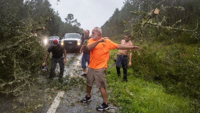 Residents try to cut their way through downed trees to return to their homes following Hurricane Idalia in Steinhatchee, Florida, US, on Wednesday, Aug. 30, 2023.