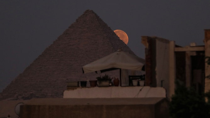 A view of supermoon known as 'blue moon' behind the Pyramids of Giza in Egypt on August 31, 2023.