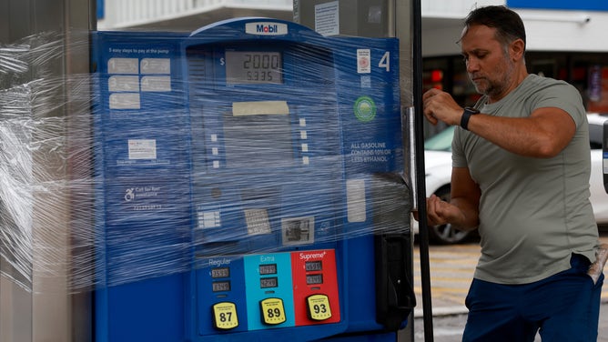 CLEARWATER BEACH, FLORIDA - AUGUST 29: Nazih Tageddine wraps cellophane around his gas pump to prevent it from being damaged by the rain from Hurricane Idalia as it passes offshore on August 29, 2023 in Clearwater Beach, Florida. Hurricane Idalia is forecast to make landfall on the Gulf Coast of Florida Wednesday morning. (Photo by Joe Raedle/Getty Images)