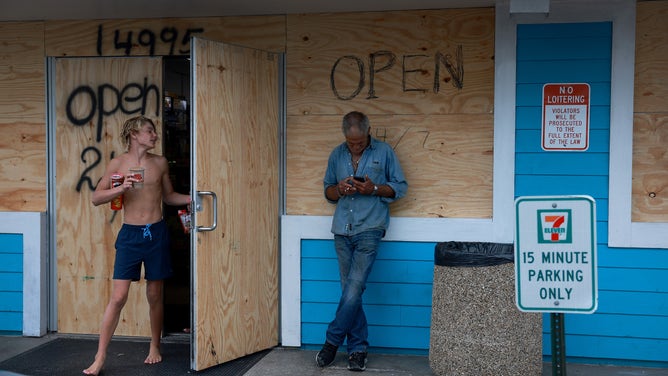 CLEARWATER BEACH, FLORIDA - AUGUST 29: Dave Bigham stands near the entrance to a 7-11 that has been boarded up to protect it from Hurricane Idalia on August 29, 2023 in Clearwater Beach, Florida. Hurricane Idalia is forecast to make landfall on the Gulf Coast of Florida Wednesday morning. (Photo by Joe Raedle/Getty Images)