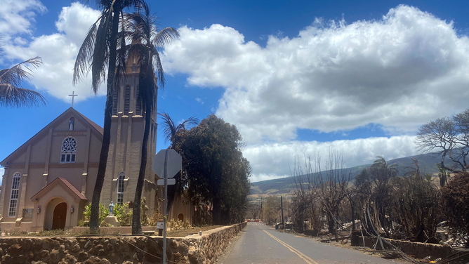 Burned houses are seen adjacent of Maria Lanakila Catholic Church, on Waine street, in the aftermath of a wildfire in Lahaina, western Maui, Hawaii on August 11, 2023. A wildfire that left Lahaina in charred ruins has killed at least 55 people, authorities said on August 10, making it one of the deadliest disasters in the US states history. Brushfires on Maui, fueled by high winds from Hurricane Dora passing to the south of Hawaii, broke out August 8 and rapidly engulfed Lahaina.