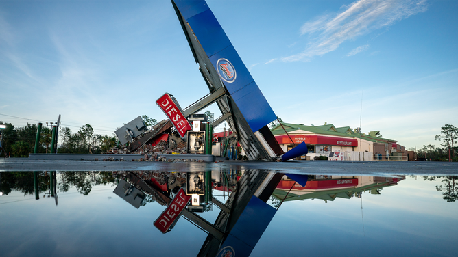 PERRY, FLORIDA - AUGUST 30: A storm-damaged gas station is reflected in a puddle after Hurricane Idalia crossed the state on August 30, 2023 in Perry, Florida. The storm made landfall at Keaton Beach, Florida as a category 3 hurricane.