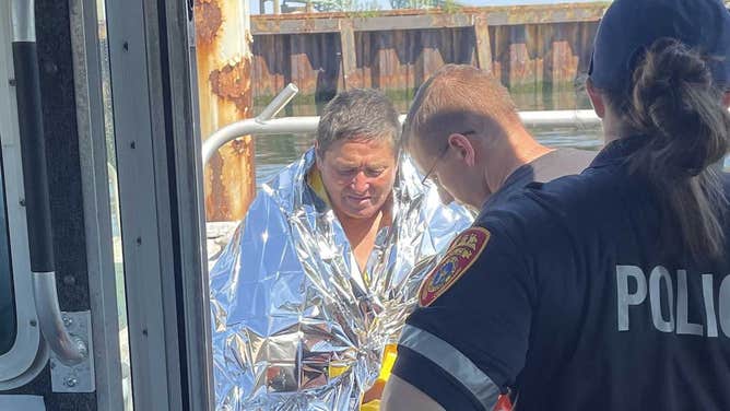 Suffolk County police provide aid to a swimmer who was carried out to sea during his swim at Cedar Beach on Monday, July 31, 2023.