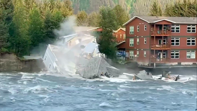 FILE: A home and trees fall into the Mendenhall River in Juneau, Alaska, on Aug. 5, 2023. The flooding was caused by a release of water from Suicide Basin.