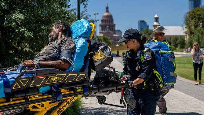 Austin-Travis County EMT assist a patient on August 08, 2023 in Austin, Texas. EMT were called after the patient was found passed out and dehydrated near the Texas State Capitol.