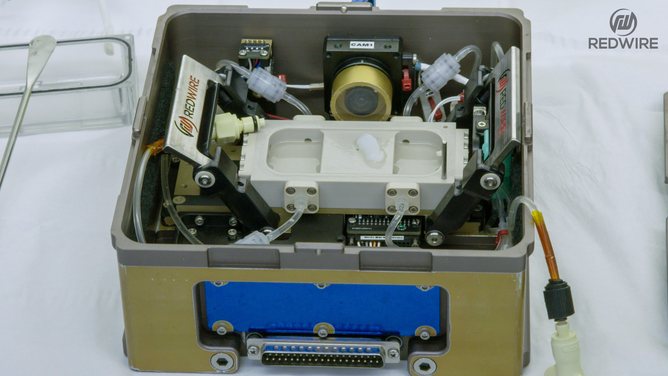 Redwire science team members opening the BFF-Meniscus-2 experiment, at the International Space Station Processing Facility. (Image credit: Redwire)