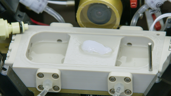 Redwire science team members opening the BFF-Meniscus-2 experiment, at the International Space Station Processing Facility. (Image credit: Redwire)