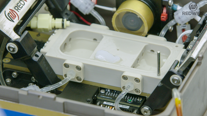 Redwire science team members opening the BFF-Meniscus-2 experiment, at the International Space Station Processing Facility. (Image credit: Redwire)