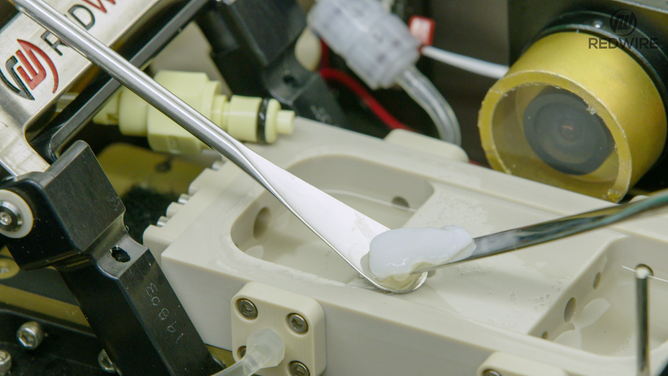 Redwire science team members opening the BFF-Meniscus-2 experiment, at the International Space Station Processing Facility. (Image credit: Redwire)