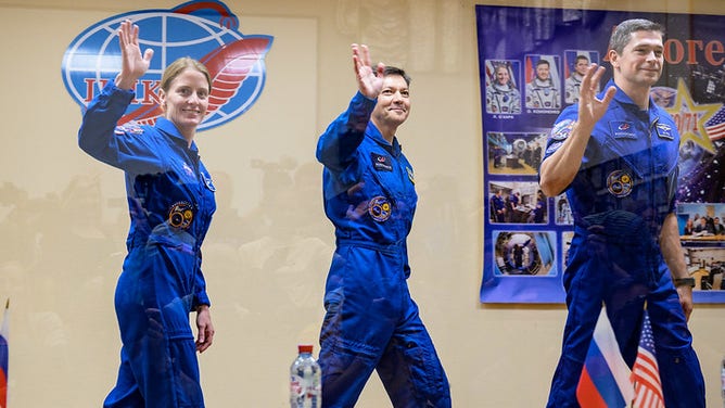 Expedition 70 NASA astronaut Loral O'Hara, left, Roscosmos cosmonauts Oleg Kononenko, and Nikolai Chub, right, wave farewell at the conclusion of a press conference, Thursday, Sept. 14, 2023 at the Cosmonaut Hotel in Baikonur, Kazakhstan. O'Hara, Kononenko, and Chub are scheduled to launch aboard their Soyuz MS-24 spacecraft on Sept. 15.