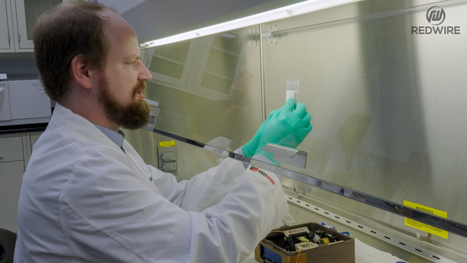 Redwire science team members opening the BFF-Meniscus-2 experiment, at the International Space Station Processing Facility. (Image credit: Redwire)
