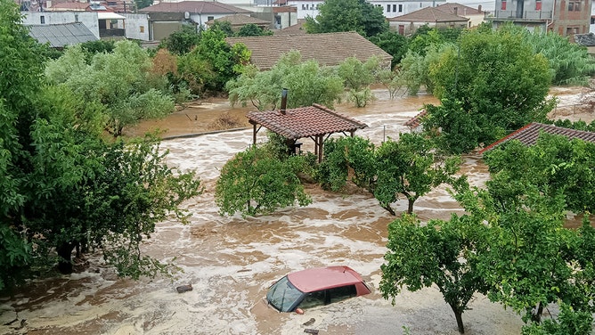 This general view shows a car and houses in a flooded area in Volos on September 5, 2023. At least one person has died in eastern Greece after torrential rains hit the country, already ravaged for weeks by devastating wildfires, authorities said on Tuesday.