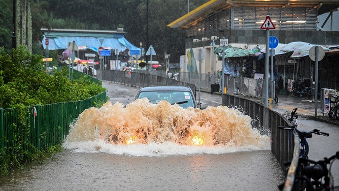 A motorist drives through floodwaters on Lantau Island in Hong Kong on September 8, 2023.