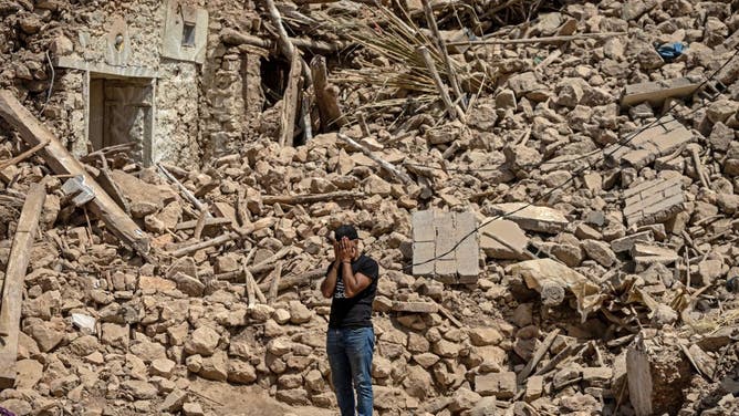 A volunteer reacts amid the rubble of destroyed houses in the village of Douzrou on September 12, 2023 following a 6.8-magnitude quake.