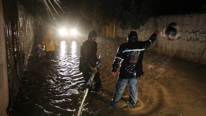 People try to open a blocked water drain in the middle of flooded road due to the Storm Daniel, which affected the city of Derna in Libya, in Deir Al Balah, Gaza on September 13, 2023.