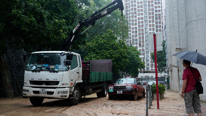 A driver operates a crane to lift a trapped taxi at the scene of a landslide caused by torrential rain at Shau Kei Wan on September 8, 2023 in Hong Kong, China. 