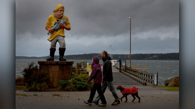People walk as the wind and rain from what was formerly Hurricane Lee and is now a post-tropical cyclone affect the area on September 16, 2023 in Eastport, Maine.