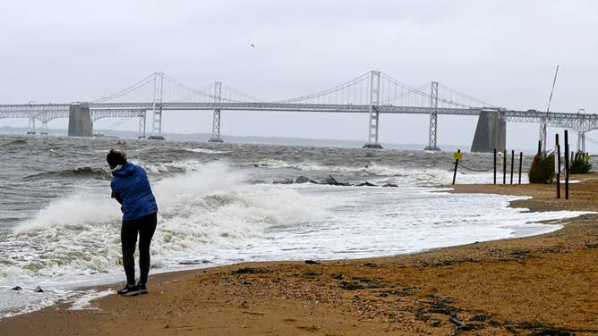 ANNAPOLIS, MD - SEPTEMBER 23: Lisa Banting of Annapolis braves the elements to get a snapshot of the waves at Sandy Point Beach as Tropical Storm Ophelia moves northward through the Mid-Atlantic this weekend dropping heavy rain and high winds on September 23, 2023.