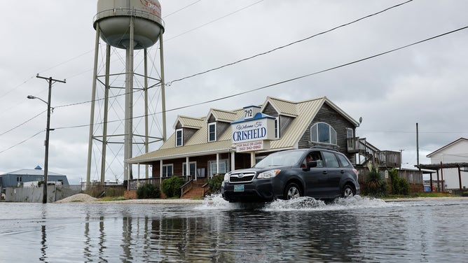 CRISFIELD, MD - SEPTEMBER 24: A vehicle moves through a flooded intersection following heavy rains from Tropical Storm Ophelia on September 24, 2023 in Crisfield, Maryland. Ophelia made landfall early Saturday in North Carolina, producing high winds and heavy rain across the Carolinas, Virginia, Maryland, Delaware, and New Jersey. The city of Crisfield will apply for Federal Emergency Management Agency and Maryland Department of Emergency Management grants to help pay for a $63 million flood control program to mitigate flooding by raising roads, and building new tide gates, berms, and other projects. 
