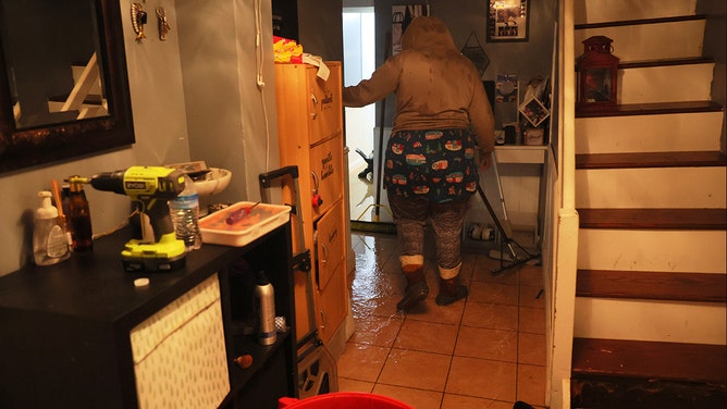 A person walks along their flooded basement on E 10th Street amid a coastal storm on September 29, 2023 in the Flatbush neighborhood of Brooklyn borough New York City.