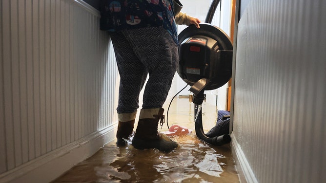 A person picks up a water pump in their flooded basement on E 10th Street amid a coastal storm on September 29, 2023 in the Flatbush neighborhood of Brooklyn borough New York City.