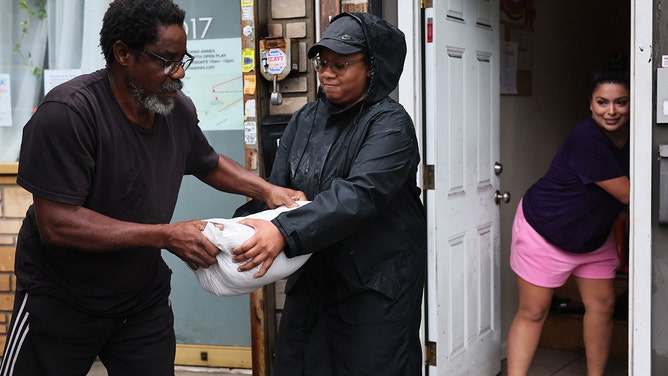 Workers of G.A.T.E.D Academy unload sandbags to stop flooding amid a coastal storm on September 29, 2023 in the Flatbush neighborhood of Brooklyn borough New York City.