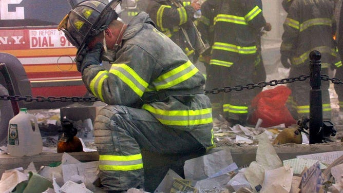 NEW YORK - SEPTEMBER 11: Firefighter Gerard McGibbon, of Engine 283 in Brownsville, Brooklyn, prays after the World Trade Center buildings collapsed September 11, 2001 after two hijacked airplanes slammed into the twin towers in a terrorist attack that killed some 3,000 people. (Photo by Mario Tama/Getty Images)