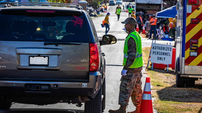 A vehicle is receiving directions after being allowed to return to areas blocked off after deadly wildfires in Lahaina, Hawaii, in August.