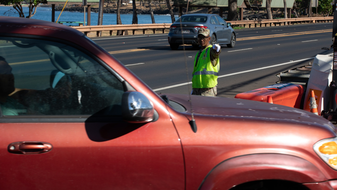 A vehicle is seen being directed at a checkpoint in Lahaina, Hawaii, on Monday, September 25, 2023.