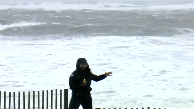 Campbell fights the wind to remain standing upright in the storm.