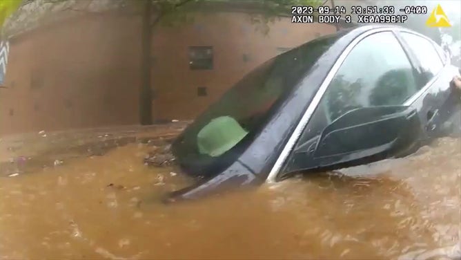 An image showing a car submerged in floodwaters in Atlanta on September 14, 2023. Police and firefighters were able to rescue the man who was trapped inside.