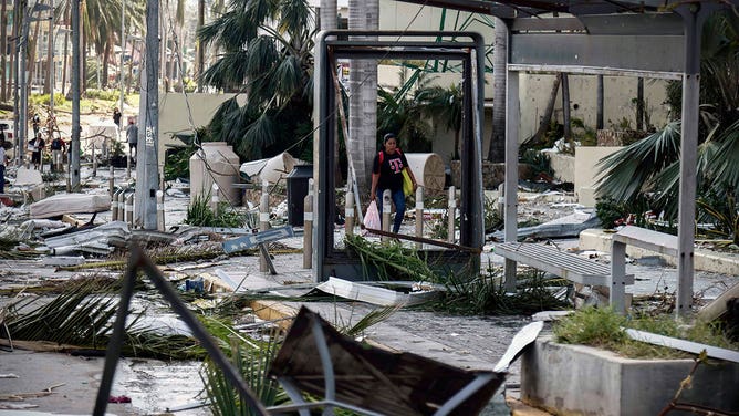 A woman walks among the debris left after the passage of Hurricane Otis in Acapulco, Guerrero State, Mexico, on October 26, 2023.